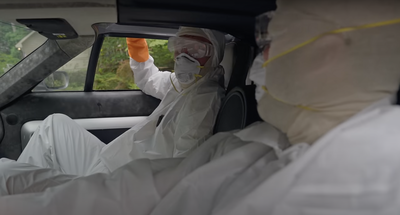 Ed Bolian and Matthew Ivanhoe wear hazmat suits in the abandoned Ford GT