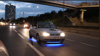 A Volkswagen Golf Cabriolet with neon lights
